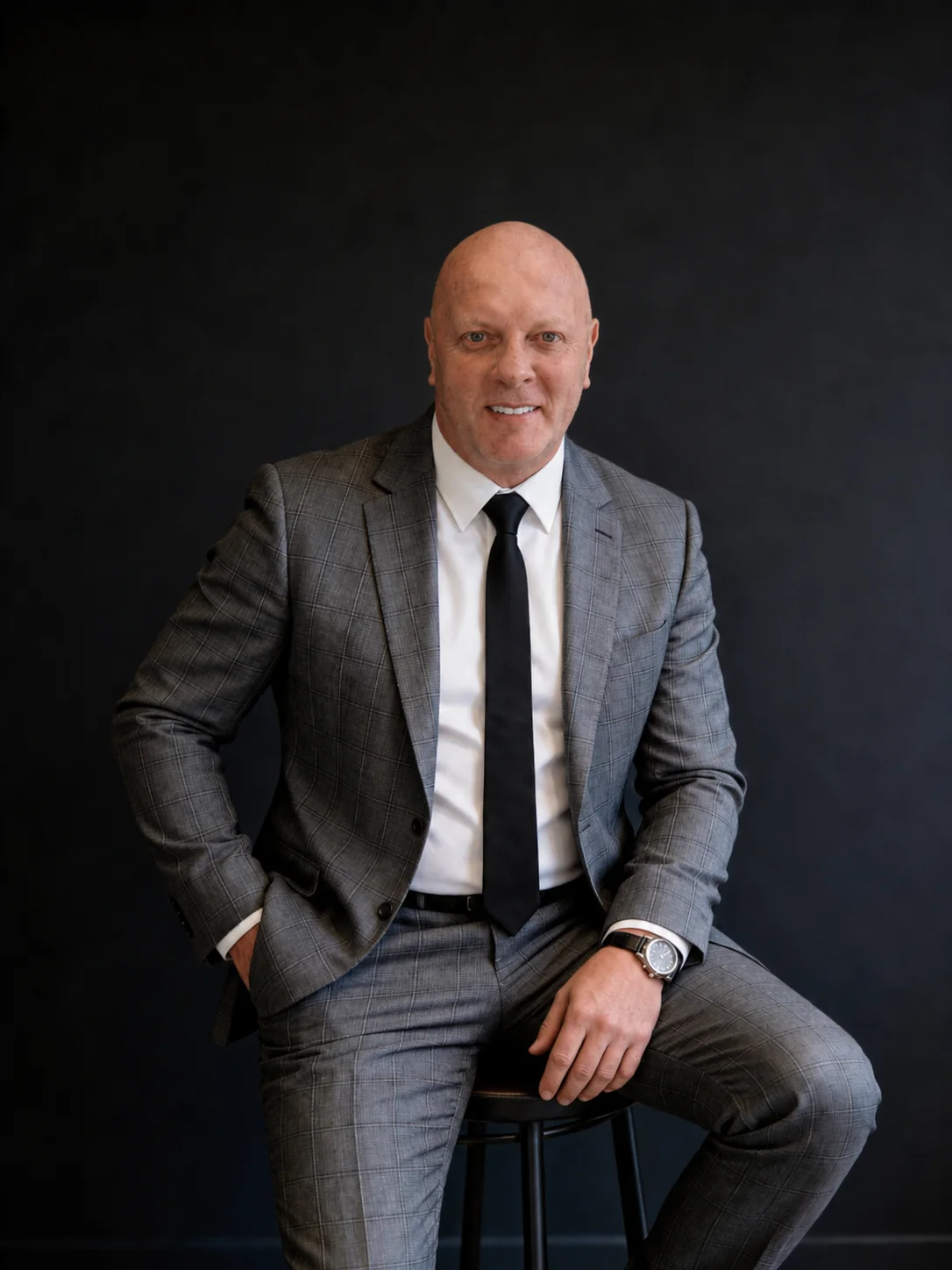 Jonathan Disley seated in a grey suit